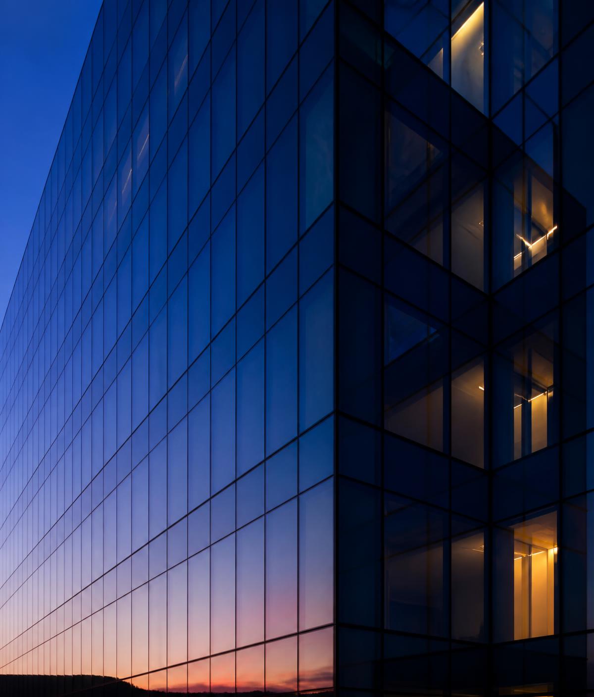 Modern glass corporate building facade at dusk